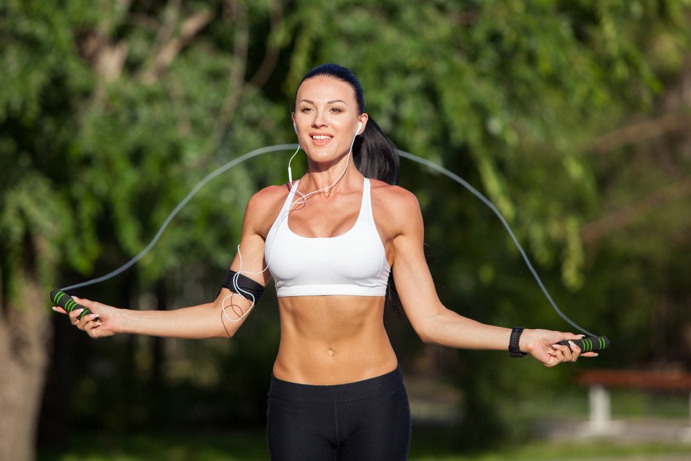 Jolie Femme Sportive Faisant De L'exercice Avec Une Corde à Sauter Dans Les  Rayons Du Soleil